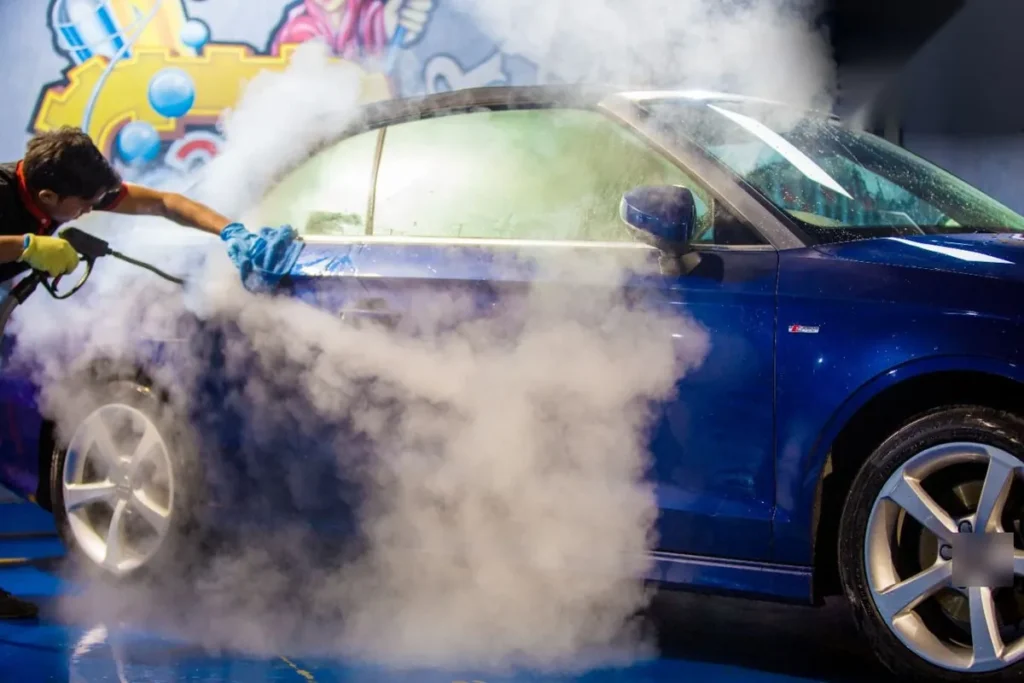 Auto azul envuelto en vapor durante un lavado a vapor de carrocería