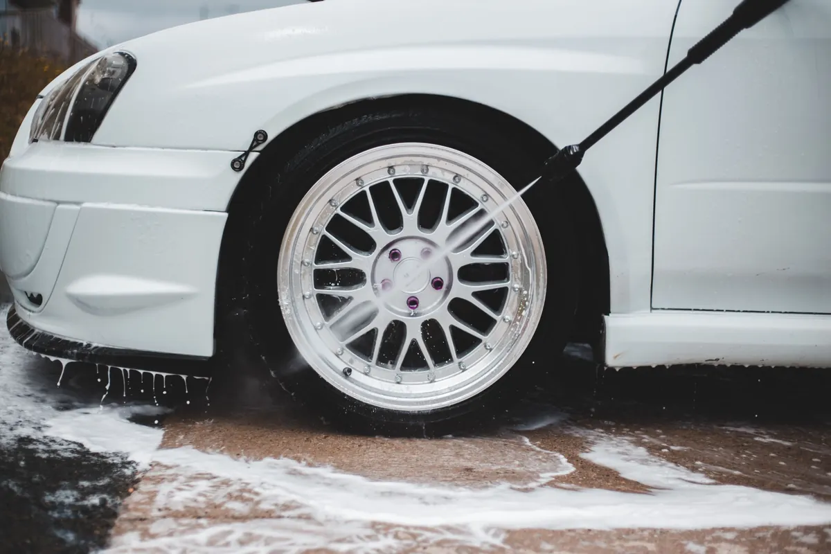 Lavado con agua a presión de un rin blanco: lavado y engrasado automotriz