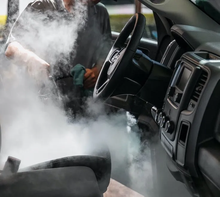 Nube de vapor dentro de la cabina de una camioneta: lavado a vapor interior de autos