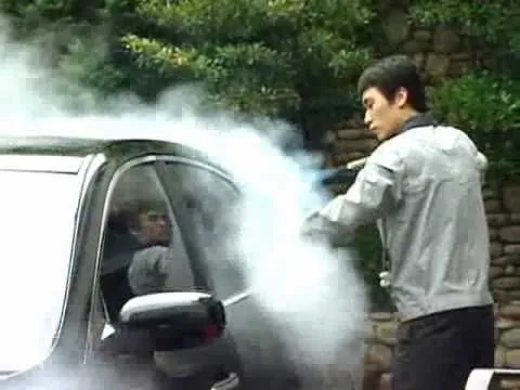 Operario aplicando vapor en la carrocería de un auto gris