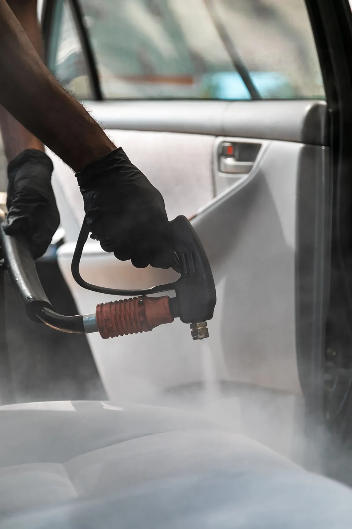 Vapor sobre la vestidura de una puerta, con guantes de trabajo