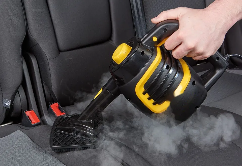 Vaporizador manual limpiando el asiento trasero de un auto